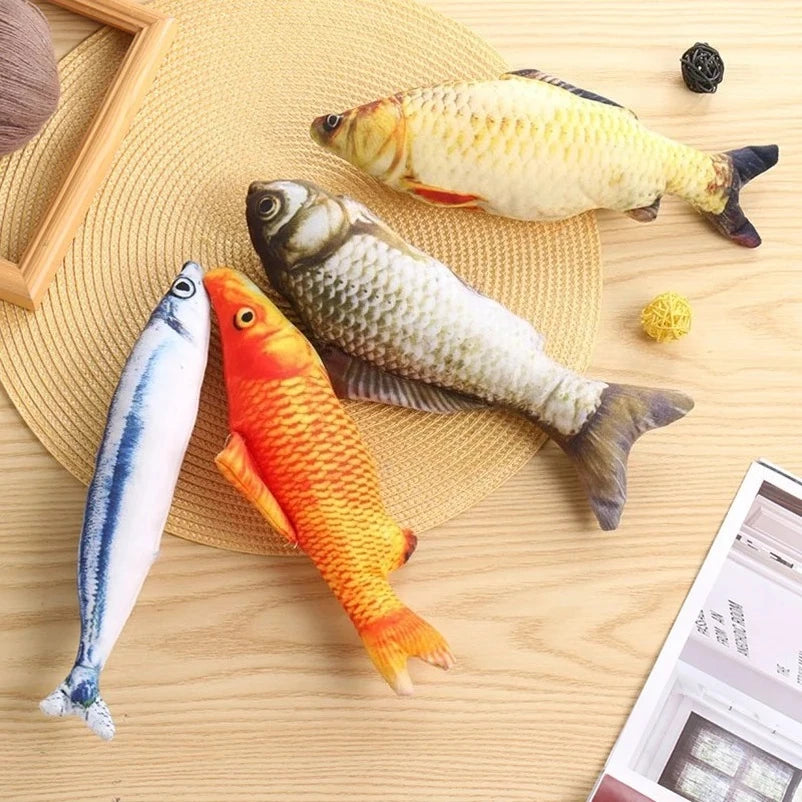A collection of plush fish toys in various colors and sizes resting on a light wooden surface.