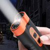 A hand holds an orange and black ultrasonic dog repeller with an LED flashlight, shining a beam in a dark outdoor setting.