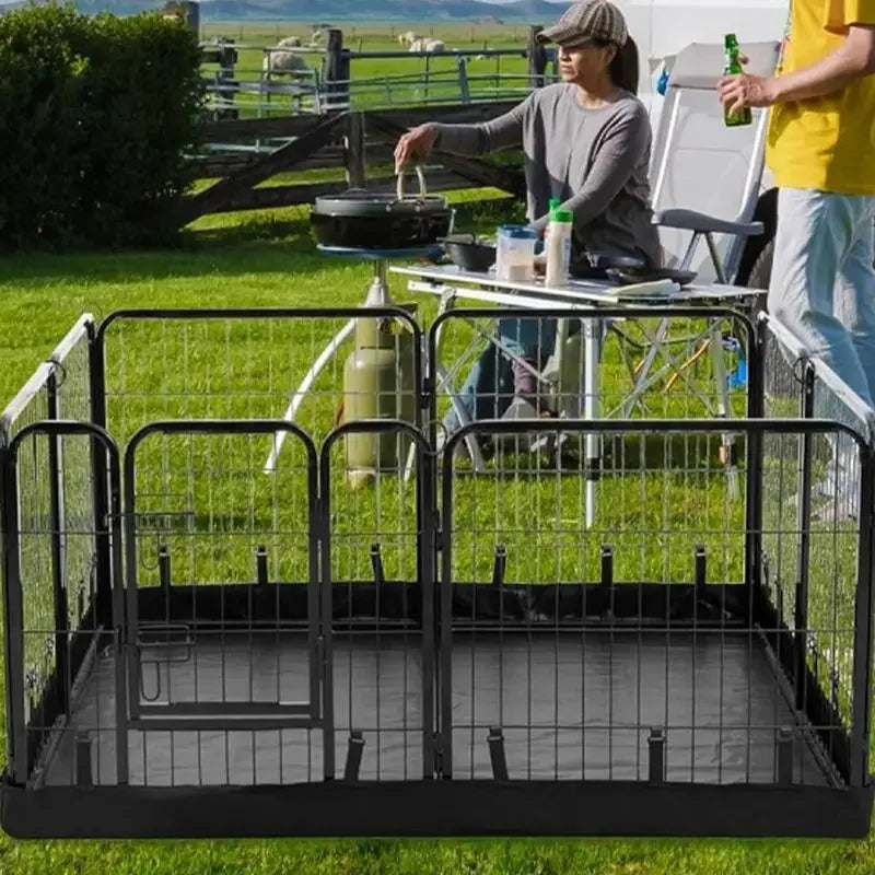 A black waterproof dog playpen mat is set up on green grass with a woman nearby.