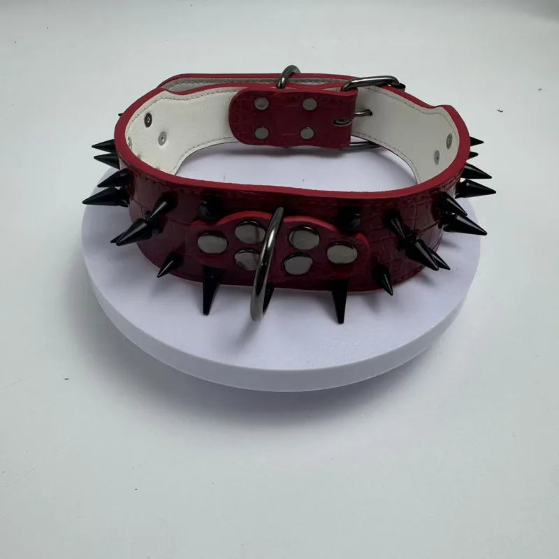 A red spiked leather collar for a dog, featuring white leather lining and silver hardware.