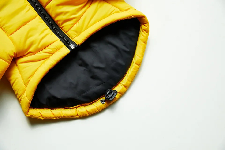 A yellow quilted coat with a black zipper is shown open, revealing the dark lining.