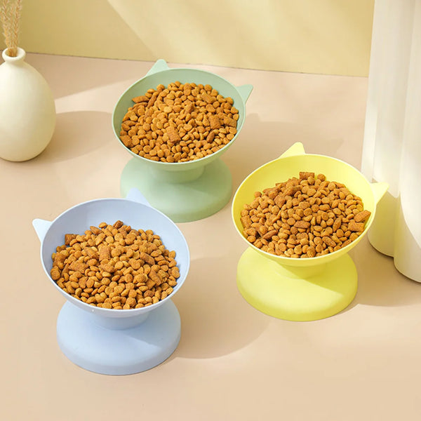 Three pet food bowls with non-slip bases are shown, filled with dry kibble, in shades of green and yellow.