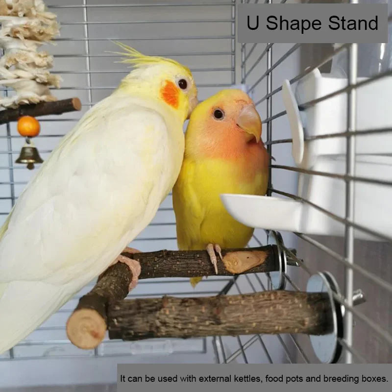 Un pájaro amarillo posado en una rama de madera natural dentro de un soporte en forma de U para aves y mascotas pequeñas.