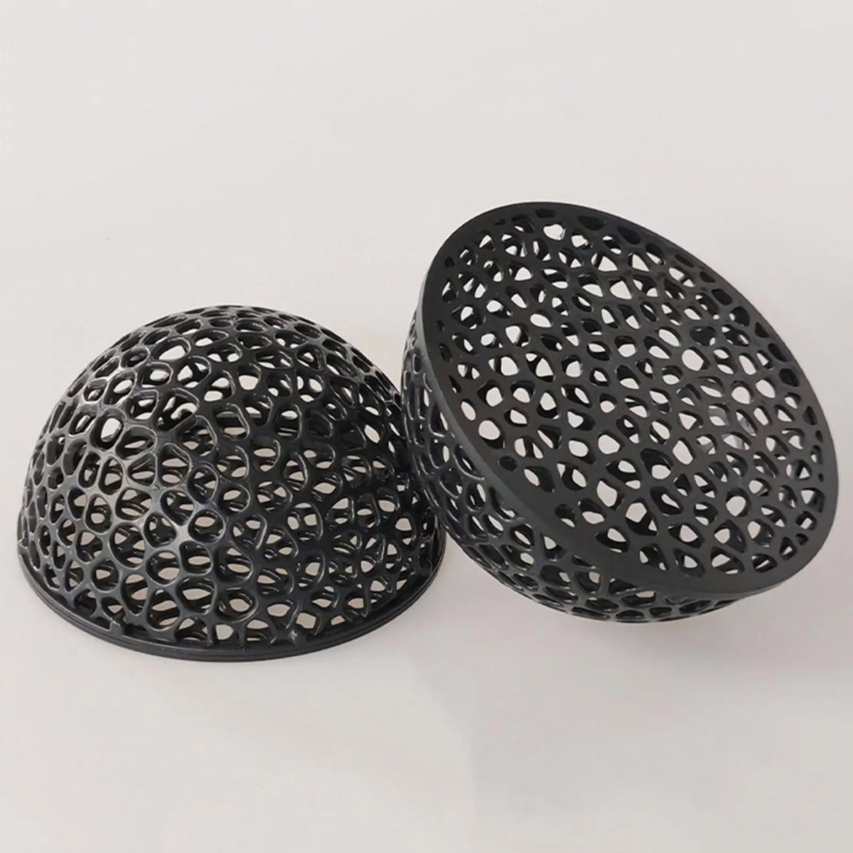 A black, spherical aquarium hideaway cave with a perforated design.