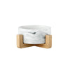 A white marbled ceramic double pet bowl set with a natural wooden stand.