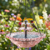 Fontaine d'oiseau solaire à plusieurs niveaux avec un bol en verre rose et un petit oiseau perché sur la structure.