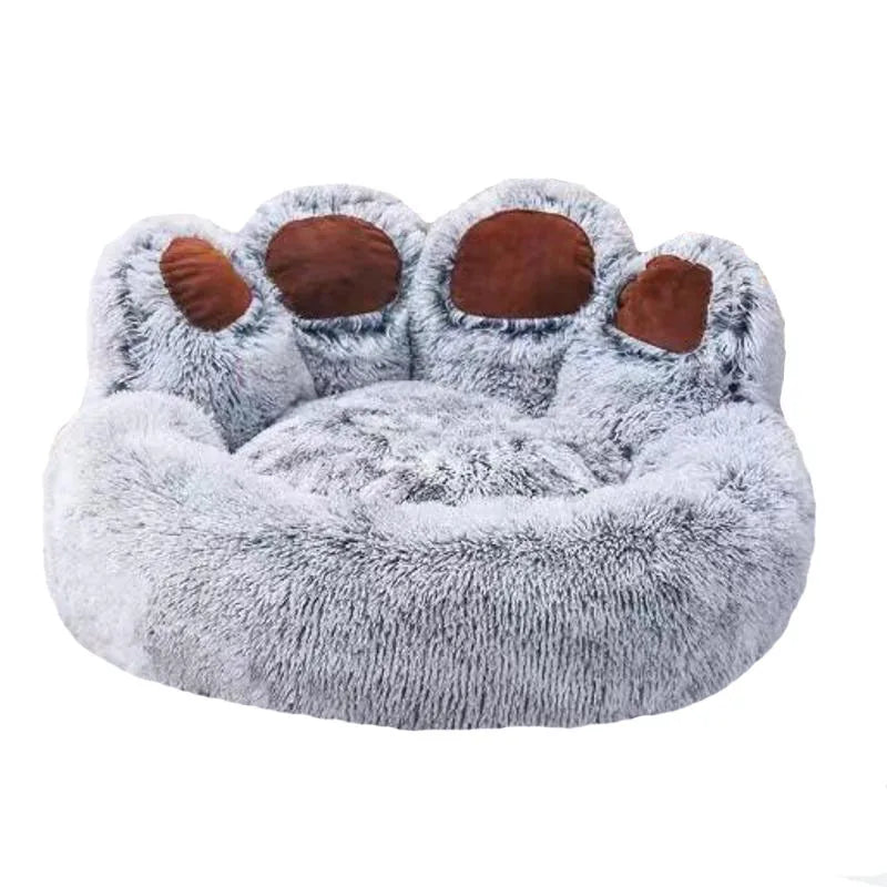 A plush fluffy dog bed with gray fur and brown paw pads.