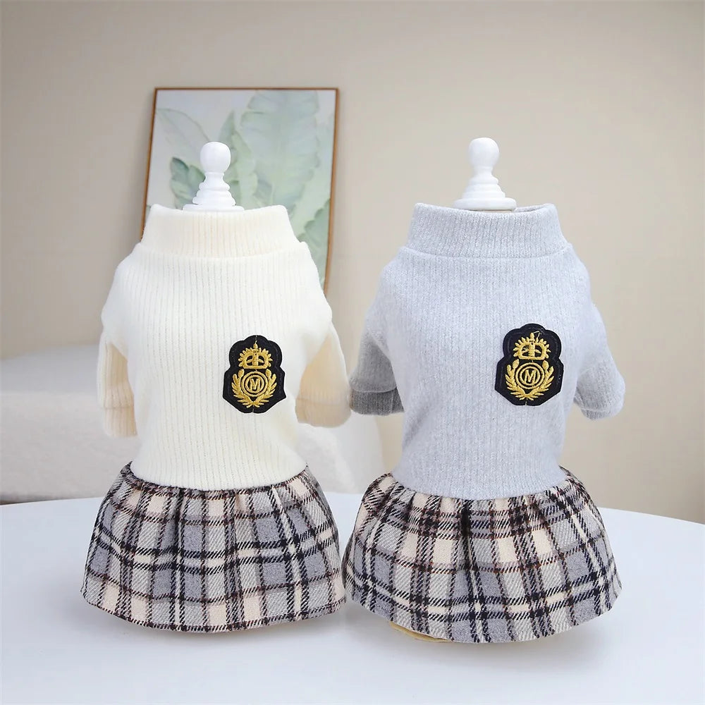 A white knitted top and plaid skirt set for a dog.