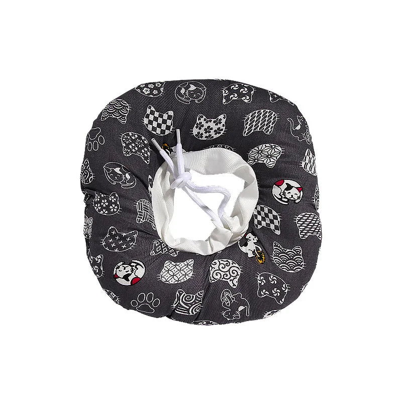 A black fabric collar with various paw print and animal designs for dogs and cats