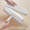 A hand is holding a white multipurpose tearable lint roller with a long extendable handle and dust cover for storage.