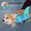 A hand is using a rescue handle on a bright blue and teal dog life jacket for a dog in the water.