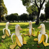 Skulptur eines weißen Enten mit gelben Akzenten in einer grünen Parklandschaft.