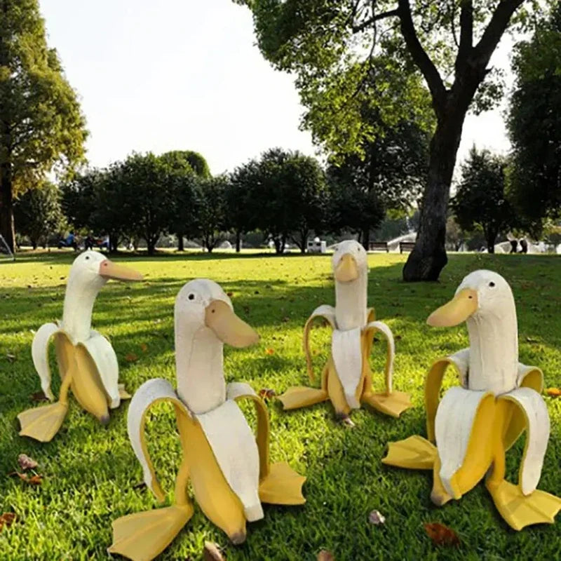 Skulptur eines weißen Enten mit gelben Akzenten in einer grünen Parklandschaft.