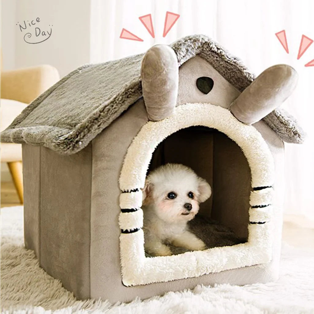 A gray foldable pet bed shaped like a house with a textured roof and an arched entrance, containing a small white puppy.