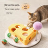 A cat is interacting with a yellow felt maze puzzle toy that has holes and a pink pom-pom attached.