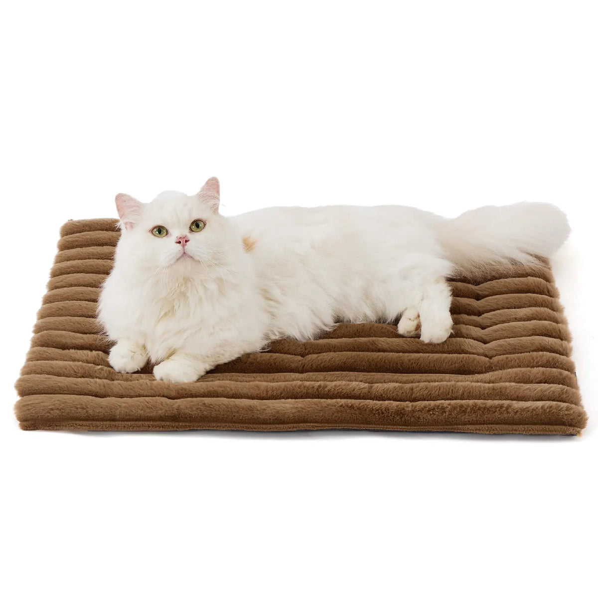 A fluffy white cat lying on a brown, ribbed pet mat.