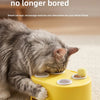 A gray cat plays with a yellow interactive toy that features a replaceable feather ball.