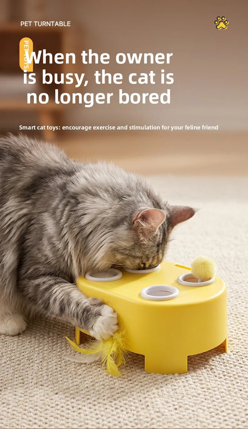 A gray cat plays with a yellow interactive toy that features a replaceable feather ball.
