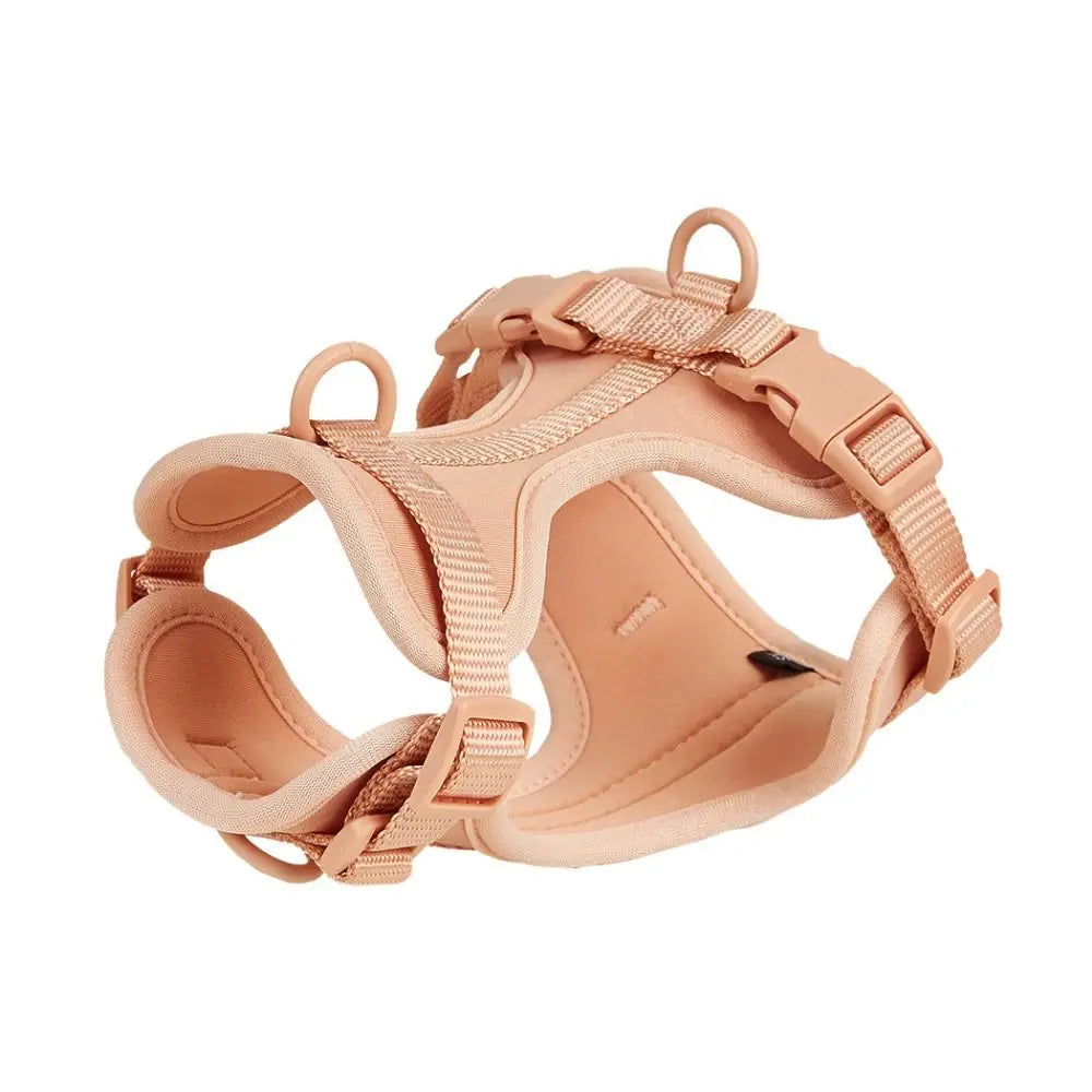 A light peach colored dog harness vest with adjustable straps and a padded seat.
