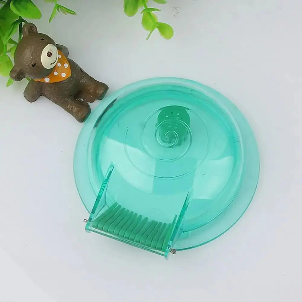 A clear teal plastic snail catcher trap with a spiral design and a small brown toy elephant nearby.