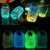 Various jars filled with glow-in-the-dark decorative pebbles showing vibrant green and blue light.