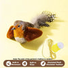 A small, realistic bird toy with orange and brown feathers is shown next to a yellow light bulb and an elastic rope.