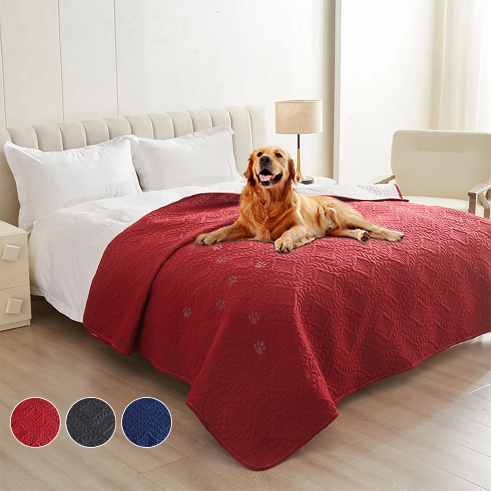A terracotta red waterproof pet bed cover protecting a dog lying on a white bed mattress.