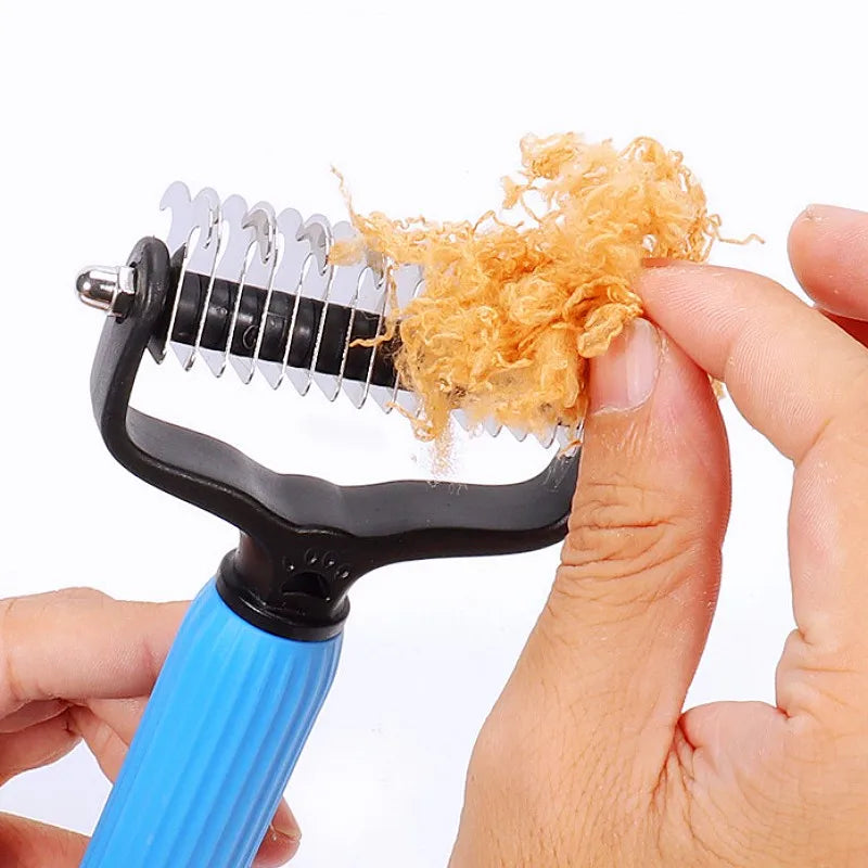 A hand holds a black and blue double-sided stainless steel comb with a yellow clump of dog hair on it.