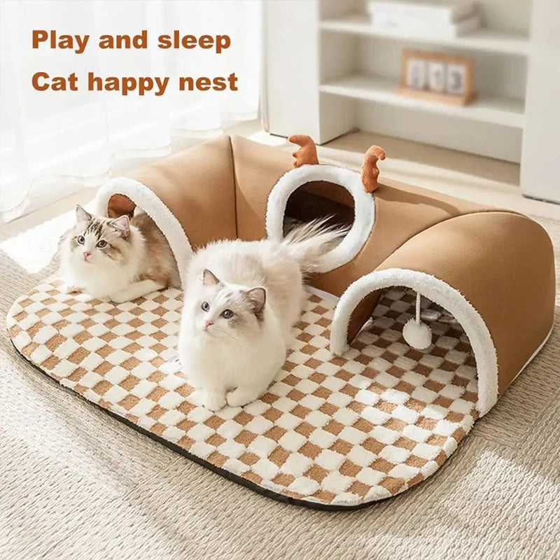 A fluffy gray cat is playing inside a brown plush cat nest with reindeer tunnels.