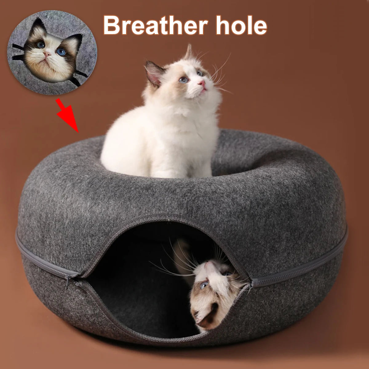 A white cat peeking out of a gray felt bed and tunnel nest designed for cats.