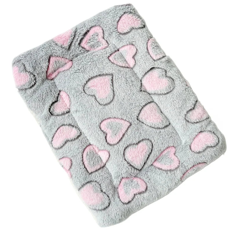 A gray plush fleece pet blanket with pink heart patterns for dogs and cats.