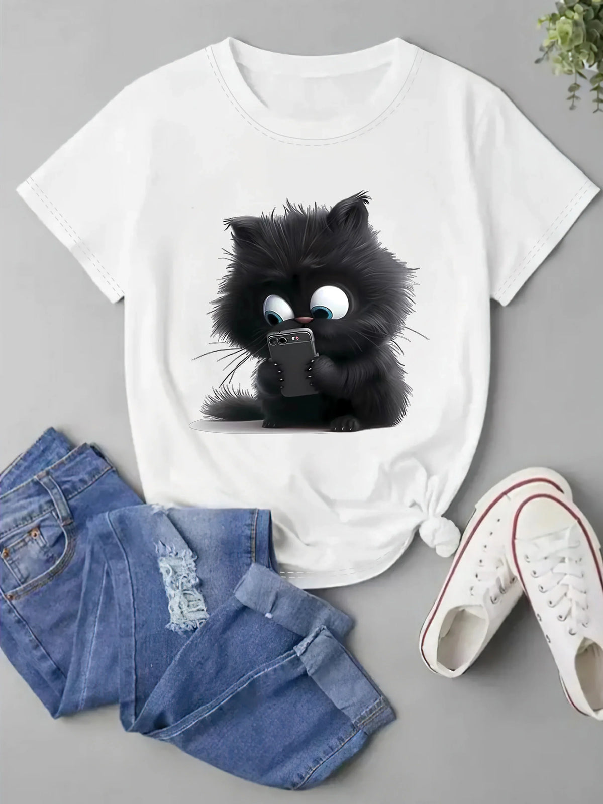 T-shirt blanc avec un motif de chat noir cartoon fantaisiste sur le devant.