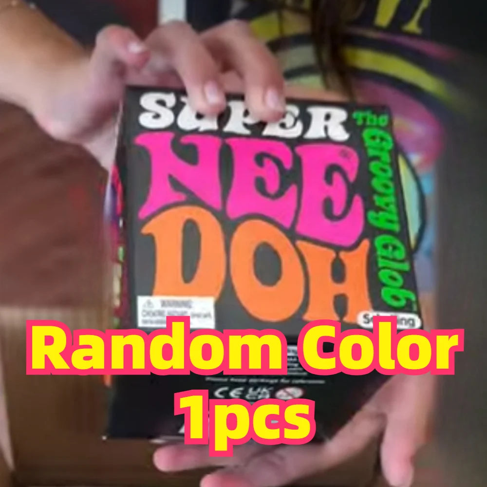 A hand holds a box of Super Nee Doh Groovy Glob stress balls, showing the colorful packaging.