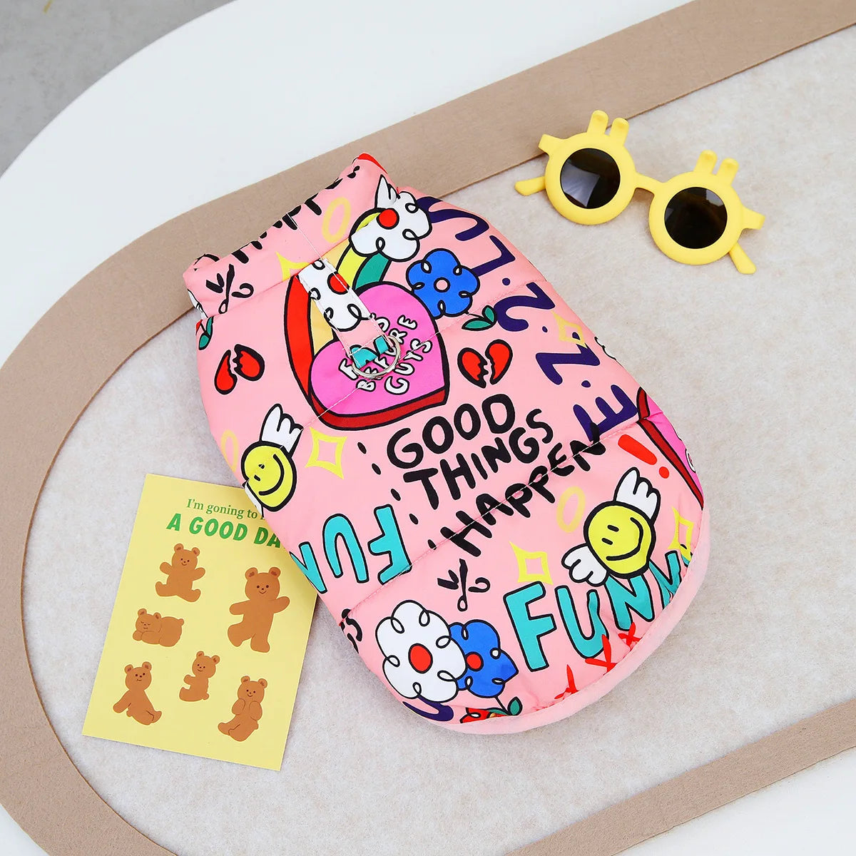 Pink waterproof dog coat featuring cute cartoon animals and a yellow pair of sunglasses