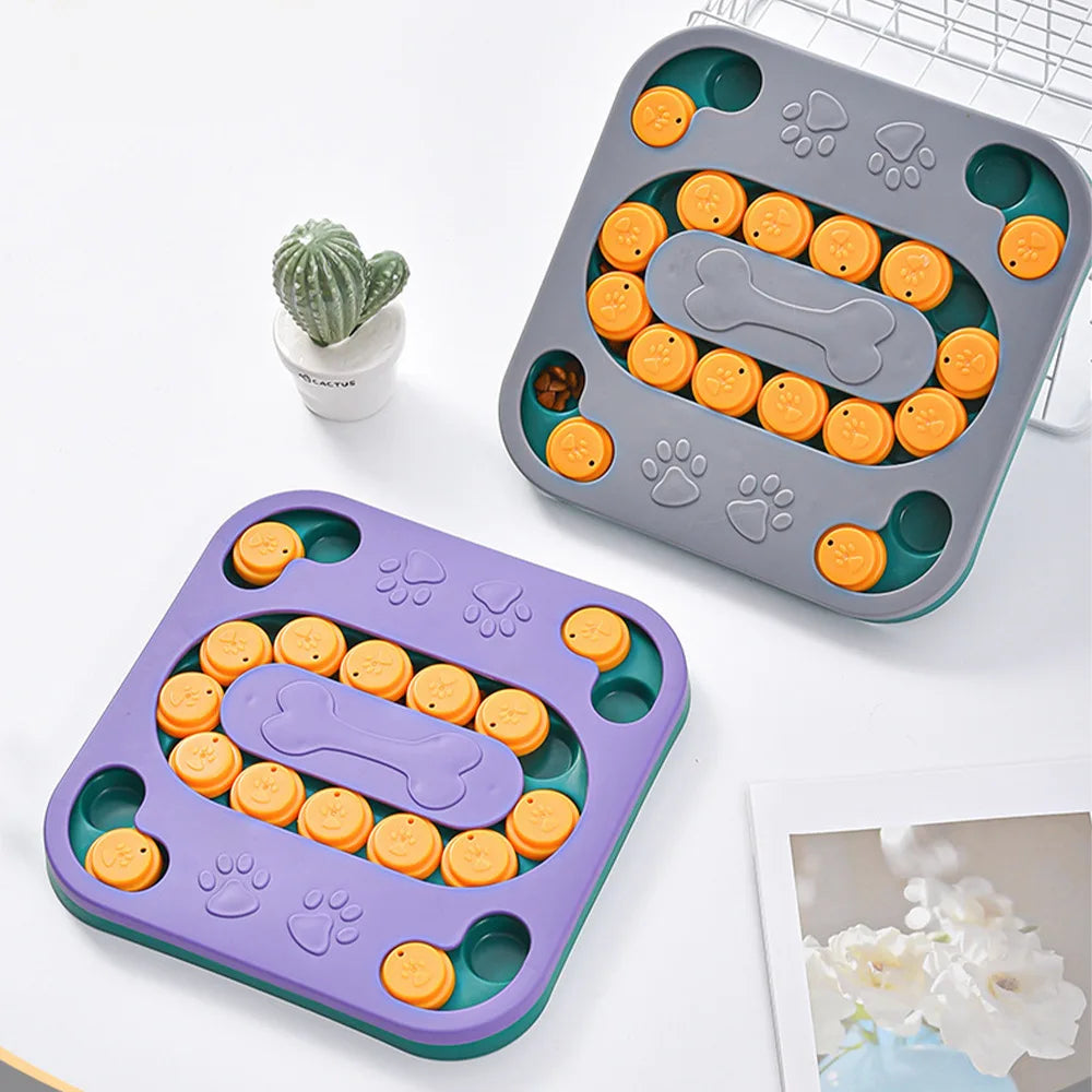 A gray silicone puzzle feeder bowl for pets with various shapes and textures, next to a small green plant.