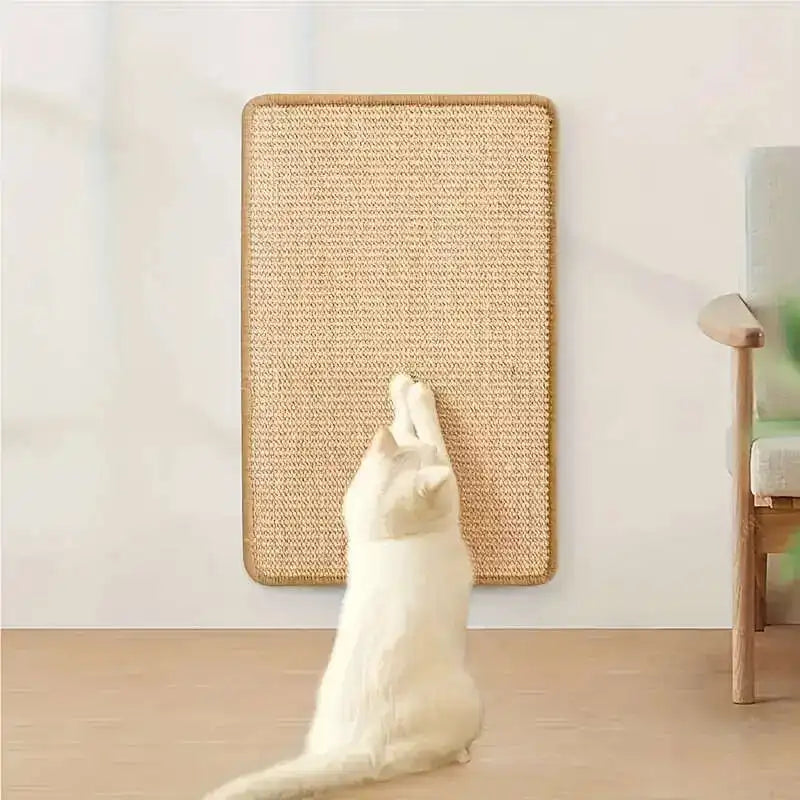 A white cat is positioned in front of a rectangular, woven hemp rope scratching board with an adhesive backing.