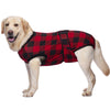 A light-colored Labrador dog wearing a red and black plaid pet recovery suit.