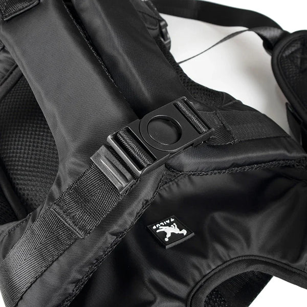 Black chest-mounted dog carrier backpack with a visible buckle and strap detail.