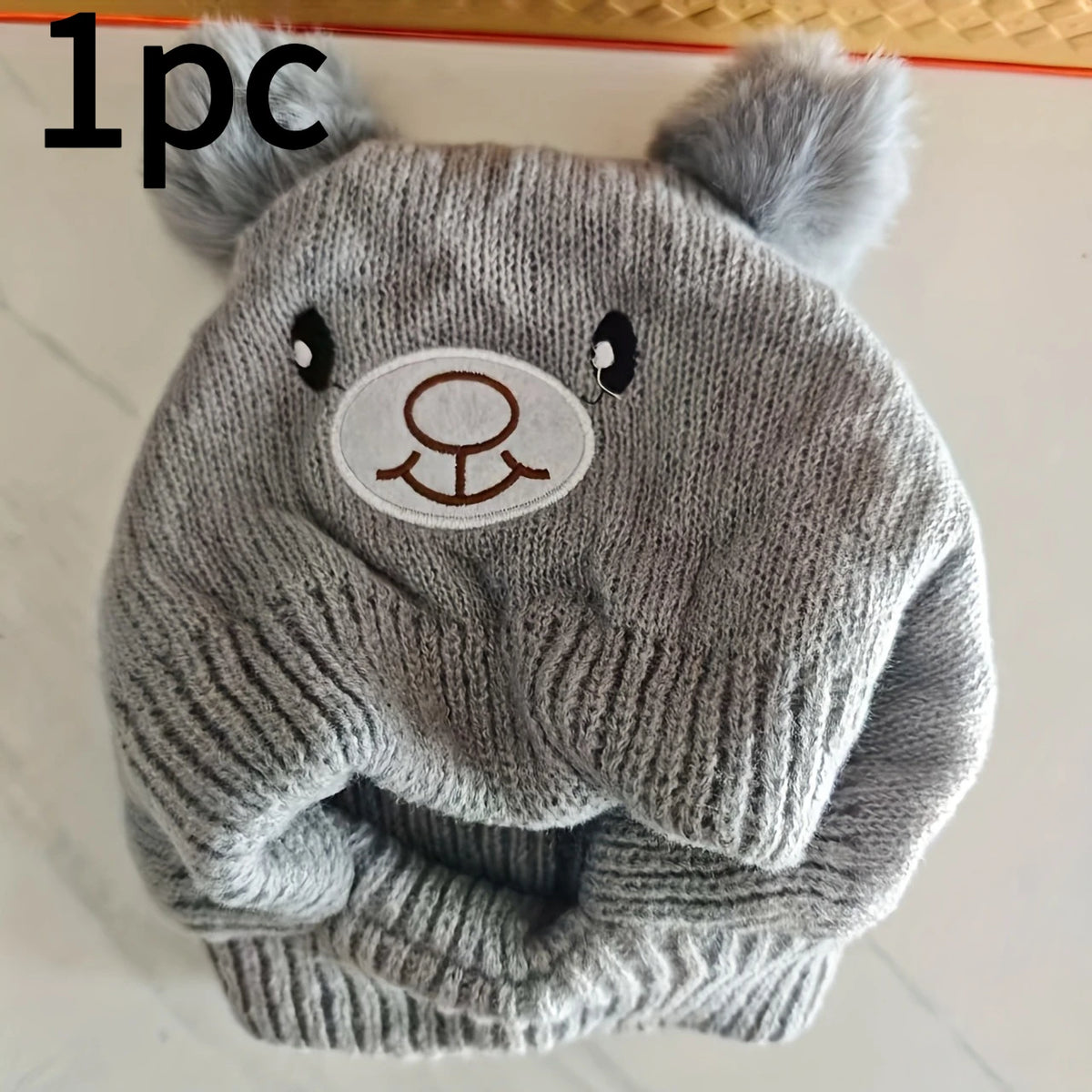 A knitted gray dog ear scarf and hat set featuring bear ears.