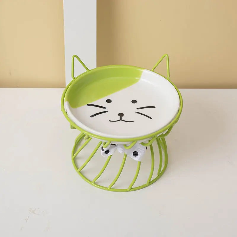 A bright lime green ceramic cat food dish with a white cat face design and a wire stand.