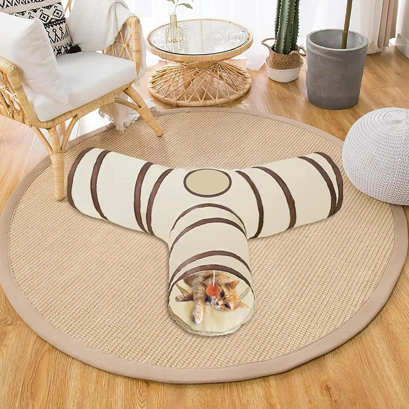 A beige foldable pet play tunnel for cats and small animals resting on a round mat.