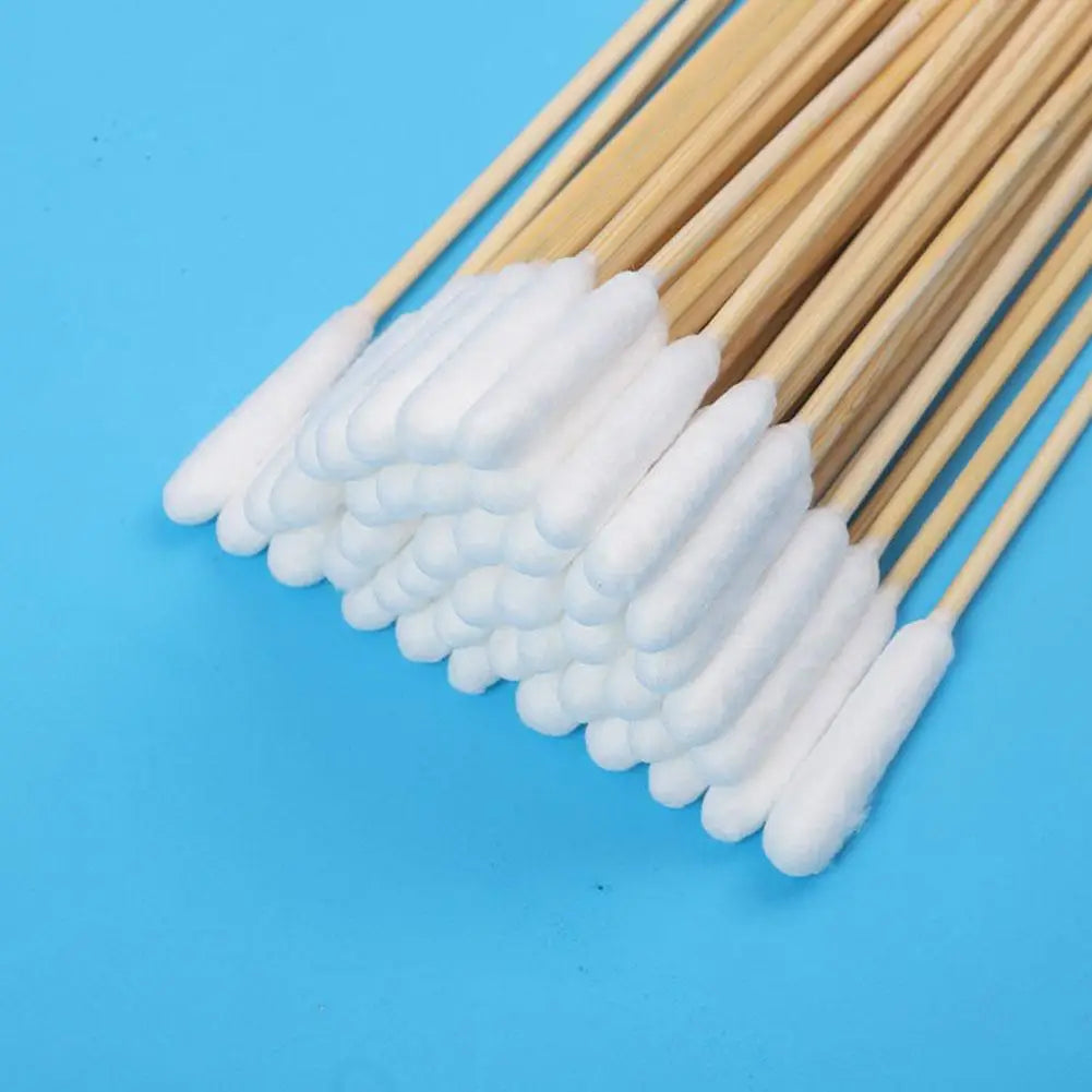 A bundle of white cotton swabs with wooden sticks arranged diagonally on a blue background.