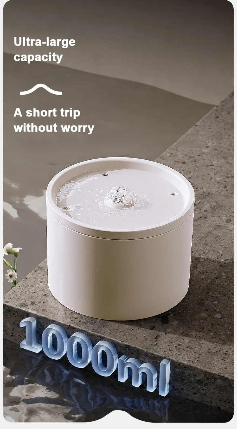 A white ceramic automatic pet water fountain with water flowing and a 1000ml capacity marker.
