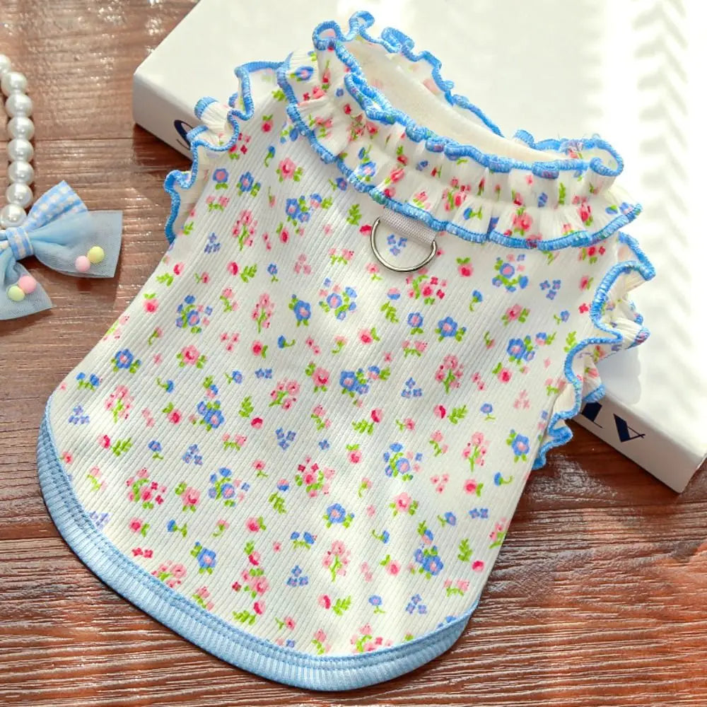 A floral vest for dogs and cats featuring light blue trim and a white background