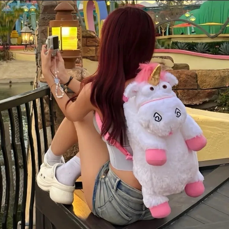 A woman is posing with a large white unicorn plush doll outdoors near a water feature.