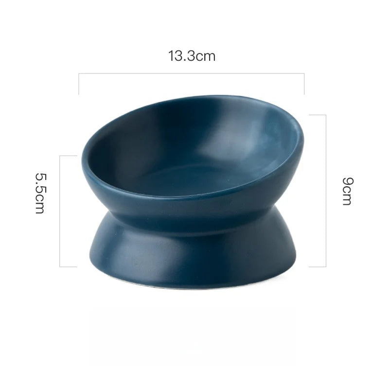 A dark blue ceramic cat bowl with a raised stand, measuring 13.3cm in diameter and 9cm in height.