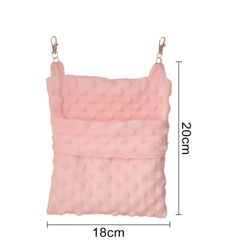 A pink, quilted hanging sleeping bag for small pets with metal loops.