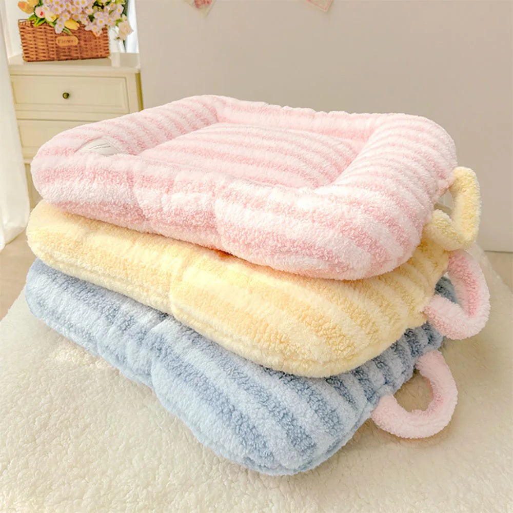 A stack of pink, yellow, and blue plush oval pet beds for cats and small dogs.
