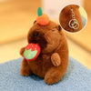 Braunes Capybara-Plüschtier mit orangefarbener Ohrmuschel und grünem Blatt-Accessoire neben einer Nahaufnahme seiner Goldkett