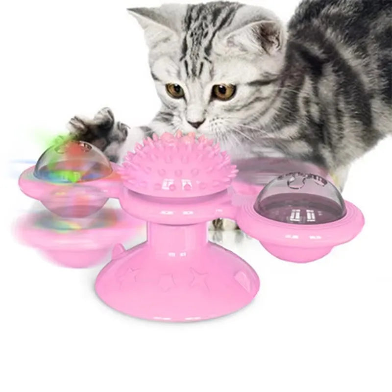Un chaton interagit avec un jouet de clochette à vent rose et multicolore.